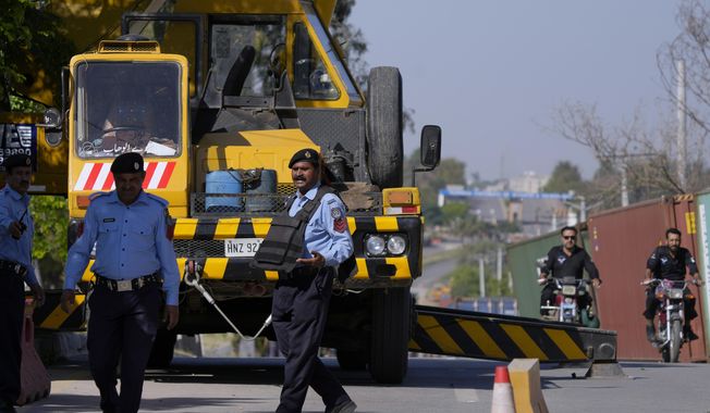 Police officers stand guard to ensure security at the vicinity of police headquarters, where Pakistan&#x27;s former Prime Minister Imran Khan is held and will appear in a temporary court set up by authorities for security reasons, in Islamabad, Pakistan, Wednesday, May 10, 2023. The opposition party of Pakistan&#x27;s former Prime Minister Khan called for demonstrators to remain peaceful, hours after mobs angered over the dramatic mid-trial arrest set fire to the residence of a top army general in the eastern city of Lahore. (AP Photo/Anjum Naveed)