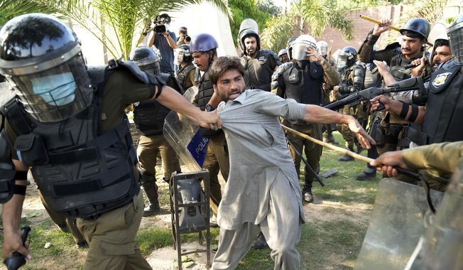 Police detain a supporter of Pakistan&#x27;s former Prime Minister Imran Khan who with others are protesting against the arrest of their leader, in Lahore, Pakistan, Wednesday, May 10, 2023. Khan can be held for eight days, a court ruled Wednesday, a day after the popular opposition leader was dragged from a courtroom and arrested on corruption charges, deepening the country&#x27;s political turmoil. (AP Photo/K.M. Chaudary)