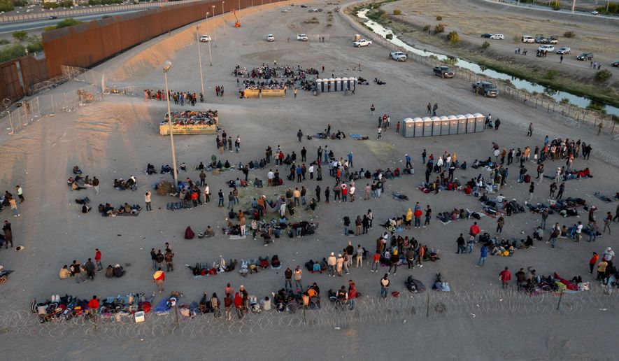 Migrants wait outside a gate in the border fence to enter into El Paso, Texas, to be processed by the Border Patrol, Thursday, May 11, 2023. Migrants rushed across the Mexico border, racing to enter the U.S. before pandemic-related asylum restrictions are lifted in a shift that threatens to put a historic strain on the nation&#x27;s beleaguered immigration system. (AP Photo/Andres Leighton)