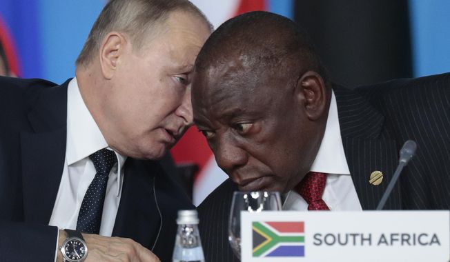 Russian President Vladimir Putin, left, speaks to South African President, Cyril Ramaphosa, right, during a plenary session at the Russia-Africa summit in the Black Sea resort of Sochi, Russia on Oct. 24, 2019. The U.S. ambassador to South Africa, Reuben Brigety, has accused South Africa of providing weapons to Russia saying the U.S. government was certain that weapons were loaded onto a cargo ship that docked secretly at a naval base near the city of Cape Town for three days in December. (Sergei Chirikov/Pool Photo via AP, File)