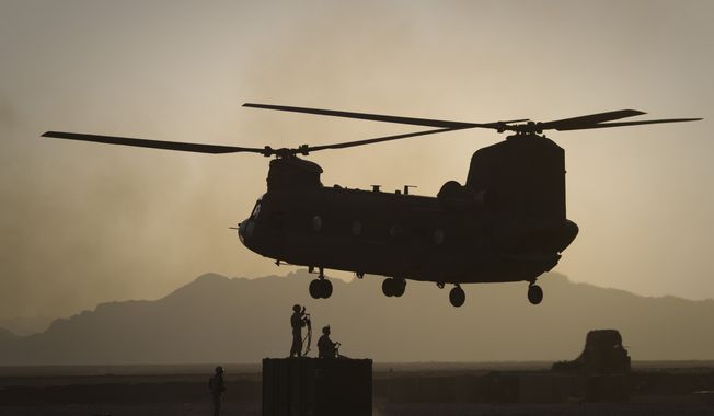 FILE - U.S. Marines direct a Chinook helicopter arriving to pick up a container with supplies at Forward Operating Base Edi in the Helmand Province of southern Afghanistan on June 9, 2011. The Biden administration on Thursday, May 11, 2023, approved an $8.5 billion sale of Chinook helicopters to NATO ally Germany. The approval comes as the war in Ukraine continues to tax the military stocks of Western countries but is not directly related to the conflict. (AP Photo/Anja Niedringhaus, File)