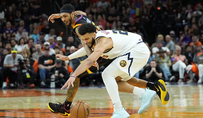 Denver Nuggets guard Jamal Murray, right, and Phoenix Suns guard Cameron Payne battle for the ball during the first half of Game 6 of an NBA basketball Western Conference semifinal game, Thursday, May 11, 2023, in Phoenix. (AP Photo/Matt York)