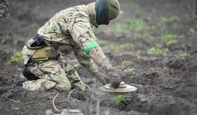 An interior ministry sapper defuses a mine on a minefield after recent battles in Irpin close to Kyiv, Ukraine, on April 19, 2022. Cyprus is working together with Irish and U.S. military experts to help train two groups of Ukrainian personnel in clearing an untold number of unmarked minefields in their homeland, the island nation&#x27;s defense minister said Friday May 12, 2023. (AP Photo/Efrem Lukatsky, File)
