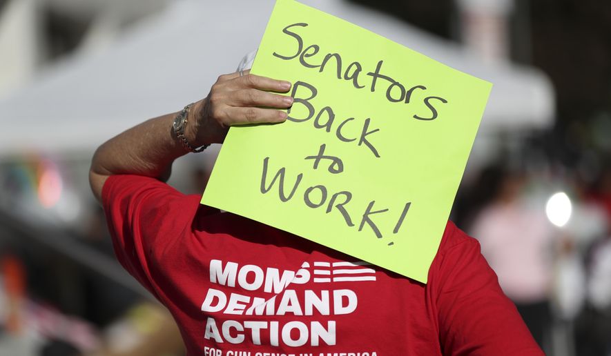 An attendee holds a sign behind their head during a rally calling for an end to the Senate Republican walkout at the Oregon State Capitol in Salem, Ore., Thursday, May 11, 2023. (AP Photo/Amanda Loman)