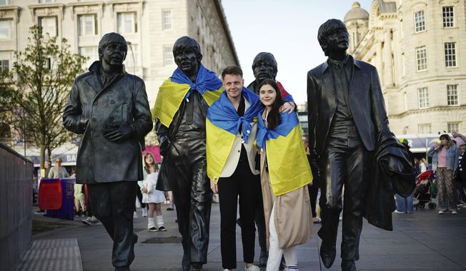 Fans put an Ukrainian flag on the Beatles Statue at Pier Head, ahead of the the Eurovision Song Contest final at the M&amp;S Bank Arena on Saturday, in Liverpool, England, Friday May 12, 2023. (Aaron Chown/PA via AP)