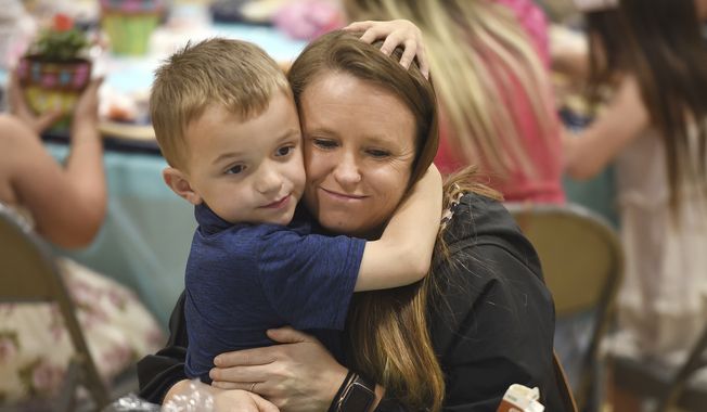Kindergartener Crue Scott 6, gives his mother, Cassie Johnson, a hug during the Mother&#x27;s Day Tea Party at Whitesville Elementary School in Whitesville, Ky., on Friday, May 12, 2023. This is the return of the long-standing tradition of the tea party at the school since it was stopped because of the COVID-19 pandemic. (Alan Warren/The Messenger-Inquirer via AP)/The Messenger-Inquirer via AP)