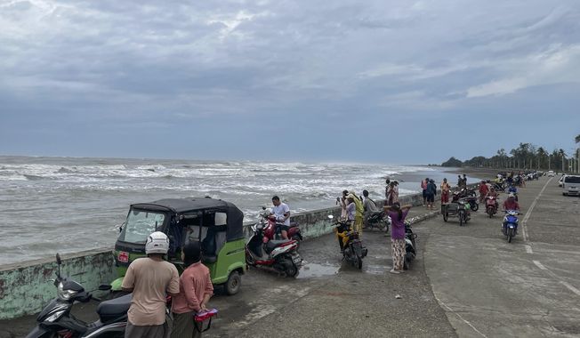 Locals stand the bank of sea before Cyclone Mocha hits, in Sittwe, Rakhine State, Saturday, May 13, 2023. Authorities in Bangladesh and Myanmar are preparing to evacuate hundreds of thousands of people as they brace for a severe cyclone churning in the Bay of Bengal. (AP Photo)