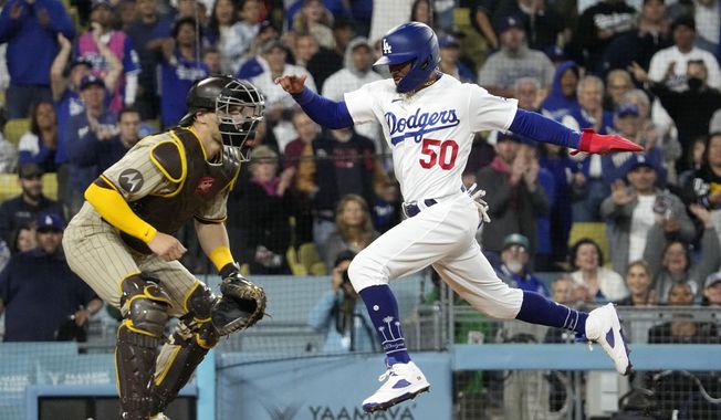 Los Angeles Dodgers&#x27; Mookie Betts, right, scores on a double by Freddie Freeman as San Diego Padres catcher Brett Sullivan waits for the ball during the third inning of a baseball game Friday, May 12, 2023, in Los Angeles. (AP Photo/Mark J. Terrill)