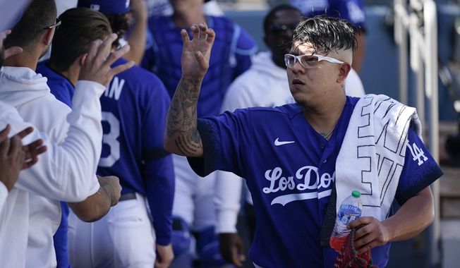 Los Angeles Dodgers starting pitcher Julio Urias (7) is greeted in the dugout before a baseball game against the San Diego Padres in Los Angeles, Saturday, May 13, 2023. (AP Photo/Ashley Landis)
