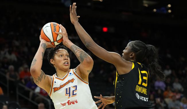 Phoenix Mercury center Brittney Griner (42) shoots over Los Angeles Sparks forward Chiney Ogwumike (13) during the first half of a WNBA preseason basketball game, Friday, May 12, 2023, in Phoenix. (AP Photo/Matt York)
