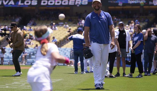 Los Angeles Dodgers starting pitcher Clayton Kershaw (22) plays ball with his daughter before the start of a baseball game against the San Diego Padres Sunday, May 14, 2023, in Los Angeles. (AP Photo/Allison Dinner)