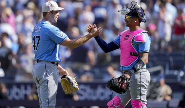 Tampa Bay Rays relief pitcher Jason Adam (47) celebrates with catcher Christian Bethancourt (14) after closing the ninth inning of a baseball game against the New York Yankees, Sunday, May 14, 2023, in New York. (AP Photo/John Minchillo)