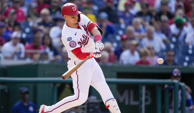 Washington Nationals designated hitter Joey Meneses hits an RBI-double during the third inning of a baseball game against the New York Mets at Nationals Park, Monday, May 15, 2023, in Washington. (AP Photo/Alex Brandon)