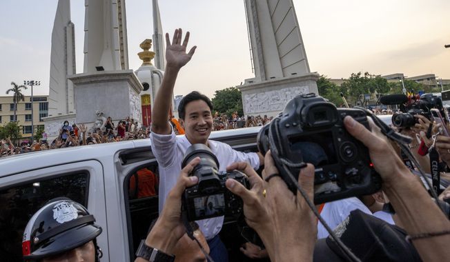 Pita Limjaroenrat, center, leader of Move Forward Party, waves to his supporters, in Bangkok, Monday, May 15, 2023. Fresh off a stunning election victory in which they together captured a majority of seats in the House of Representatives, Thailand&#x27;s top two opposition parties began planning Monday for the next stage in their bid to replace the military-dominated government. (AP Photo/Wason Wanichakorn)