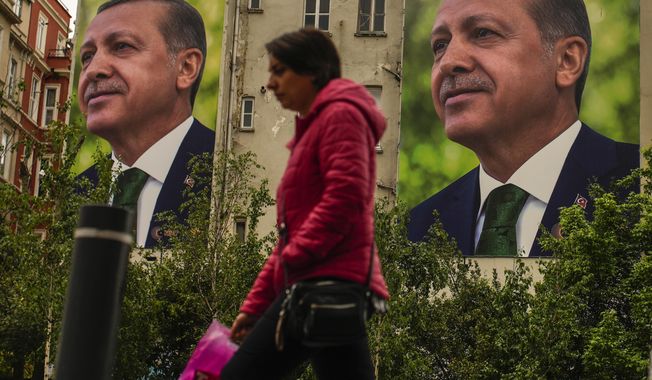 A person walks past billboards of Turkish President and People&#x27;s Alliance&#x27;s presidential candidate Recep Tayyip Erdogan a day after the presidential election day, in Istanbul, Turkey, Monday, May 15, 2023. Turkey&#x27;s presidential elections appeared to be heading toward a second-round runoff on Monday, with President Recep Tayyip Erdogan, who has ruled his country with a firm grip for 20 years, leading over his chief challenger, but falling short of the votes needed for an outright win. (AP Photo/Emrah Gurel)