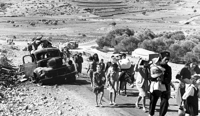 A group of Arab refugees walks along a road from Jerusalem to Lebanon, carrying their belongings with them on Nov. 9, 1948. The group was driven from their homes by attacks in Galilee. For the first time, the United Nations will officially commemorate the flight of hundreds of thousands of Palestinians from what is now Israel on the 75th anniversary of their exodus, an action stemming from the U.N.鈥檚 partition of British-ruled Palestine into separate Jewish and Arab states. (AP Photo/Jim Pringle) **FILE**