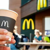 Paper cup of coffee with McDonald&#x27;s logo in hands of a woman closeup. A woman is drinking coffee on the McDonald&#x27;s outdoor terrace. File photo credit 8th.creator via Shutterstock.