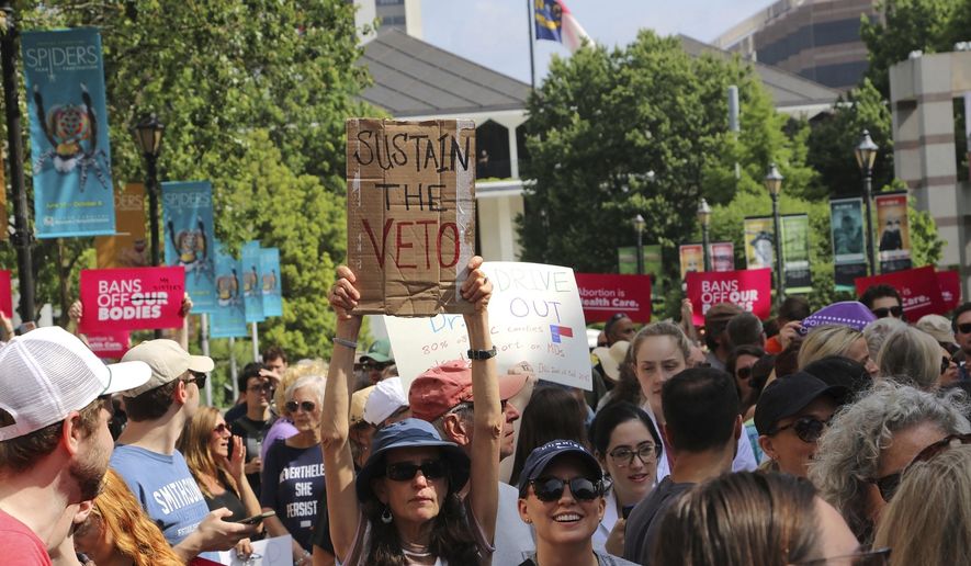 Hundreds of abortion-rights supporters rally outside the North Carolina Legislative Building in Raleigh, N.C, on Saturday, May 13, 2023, to urge Republican legislators to sustain Democratic Gov. Roy Cooper's veto of new abortion restrictions. (AP Photo/Hannah Schoenbaum)