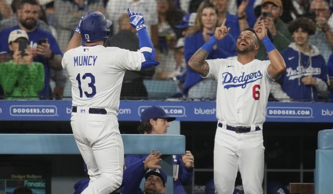 Los Angeles Dodgers&#x27; Max Muncy (13) celebrates with David Peralta (6) after he hit a home run during the third inning of a baseball game in Los Angeles, Monday, May 15, 2023. Will Smith also scored. (AP Photo/Ashley Landis)