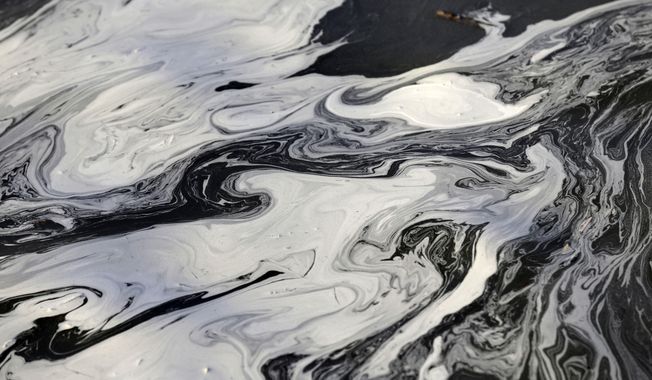 Coal ash swirls on the surface of the Dan River following one of the worst coal-ash spills in U.S. history into the river in Danville, Va., Feb. 5, 2014. The Environmental Protection Agency is moving to strengthen a rule aimed at controlling and cleaning up toxic waste from coal-fired power plants. A proposed rule announced Wednesday, May 17, 2023, would require safe management of so-called coal ash dumped in areas that currently are unregulated at the federal level. (AP Photo/Gerry Broome) **FILE**