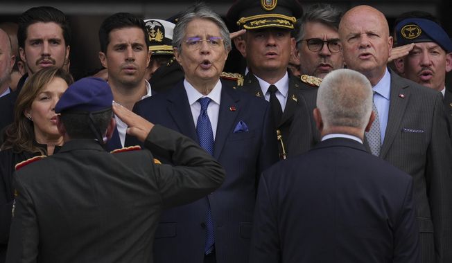 Ecuadorean President Guillermo Lasso signs his nation&#x27;s anthem as he leaves the National Assembly after addressing a session where opposition lawmakers seek to try him for embezzlement accusations in Quito, Ecuador, Tuesday, May 16, 2023. (AP Photo/Dolores Ochoa)