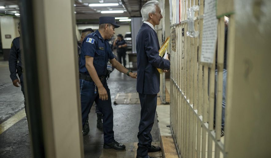 Award-winning journalist Jose Ruben Zamora is escorted by police after ending the first day of his trial on money laundering charges, in Guatemala City, Tuesday, May 2, 2023. (AP Photo/Santiago Billy)