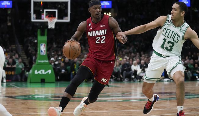 Miami Heat forward Jimmy Butler (22) drives to the basket against Boston Celtics guard Malcolm Brogdon (13) in the first half of Game 1 of the NBA basketball Eastern Conference finals playoff series in Boston, Wednesday, May 17, 2023. (AP Photo/Charles Krupa)