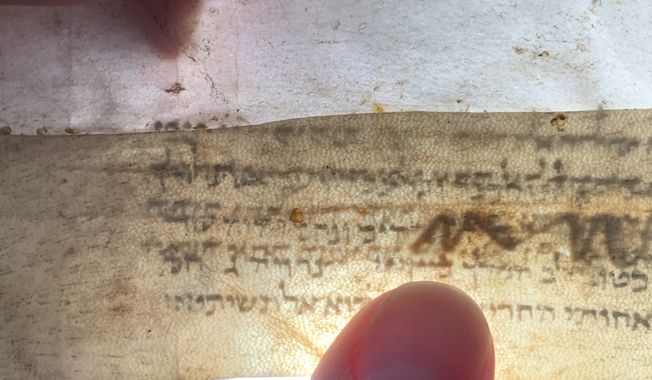 Backlighting reveals text in the Codex Sassoon &quot;hidden&quot; under leather reinforcement strips. Researcher Nehemia Gordon found the text in 2019. (Photos courtesy Institute for Hebrew Bible Manuscript Research, used with permission)
