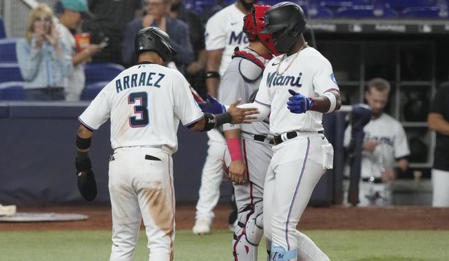 Miami Marlins designated hitter Jorge Soler (12) is congratulated by Miami Marlins second baseman Luis Arraez (3) after hitting a two-run home run in the fourth inning, Wednesday, May 17, 2023, in Miami. (AP Photo/Marta Lavandier)