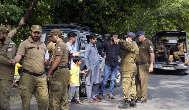 Police officers search a man at a temporary checkpoint around the home of Pakistan&#x27;s former Prime Minister Imran Khan, in Lahore, Pakistan, Wednesday, May 17, 2023. Police surrounded the home of former Prime Minister Khan on Wednesday, claiming he was sheltering dozens of people allegedly involved in violent protests over his recent detention. (AP Photo/K.M. Chaudary)