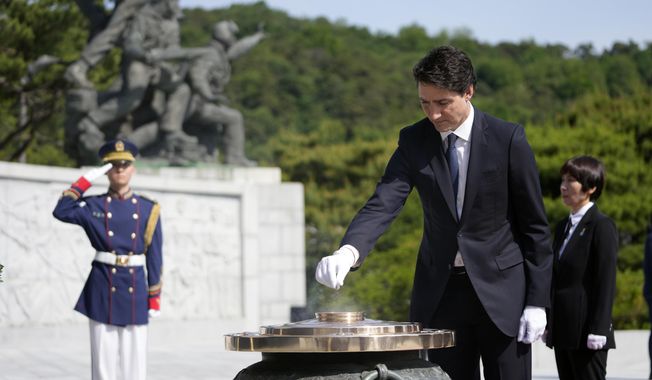 Canadian Prime Minister Justin Trudeau burns incense at the National Cemetery in Seoul, South Korea, Wednesday, May 17, 2023. (AP Photo/Lee Jin-man, Pool)