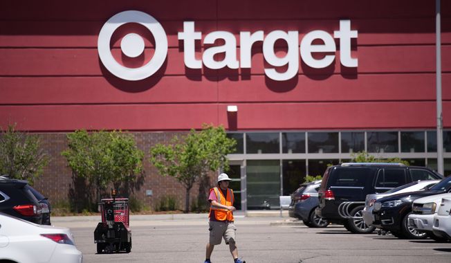 A worker collects shopping carts in the parking lot of a Target store on June 9, 2021, in Highlands Ranch, Colo. Target on Wednesday, May 17, 2023, reported another quarterly profit decline and issued a cautious sales and profit outlook for the current period. (AP Photo/David Zalubowski) **FILE**