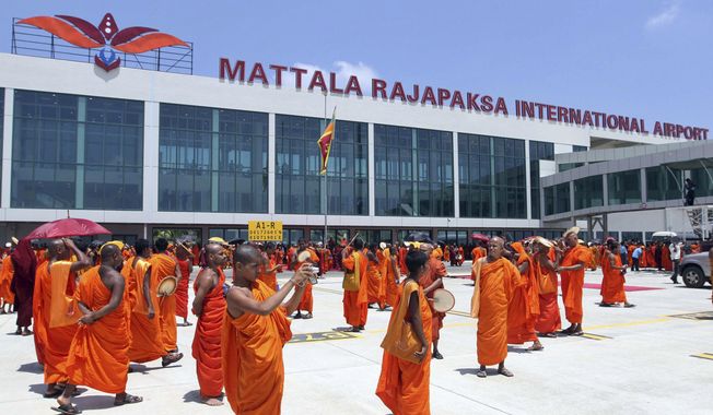 Sri Lankan Buddhist monks wait for the arrival of President Mahinda Rajapaksa at the Mattala Rajapaksa International Air Port in Mattala, Sri Lanka, Monday, March 18, 2013. The Chinese-funded airport built in the president’s hometown away from most of the country’s population is so barely used that elephants have been spotted wandering on its tarmac. (AP Photo/Sanka Gayashan, File)
