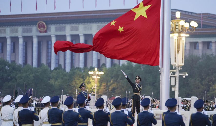 In this photo released by Xinhua News Agency, a member of the Chinese honor guard unfurls the Chinese national flag during a flag-raising ceremony to mark the 73rd anniversary of the founding of the People's Republic of China, held at Tiananmen Square in Beijing on Oct. 1, 2022. (Chen Zhonghao/Xinhua via AP, File)