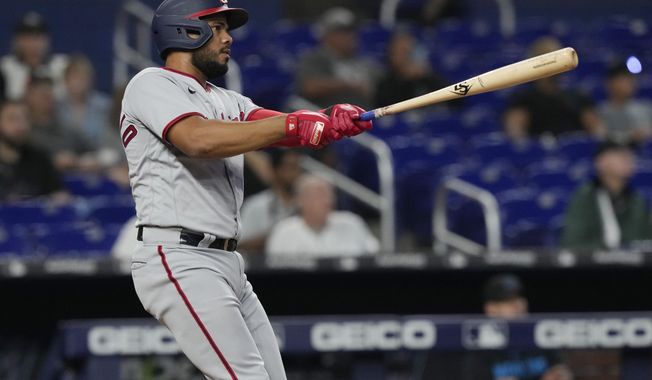 Washington Nationals Jeimer Candelario (9) watches his home run go over the center field wall during the fourth inning of a baseball game against the Miami Marlins, Thursday, May 18, 2023, in Miami. (AP Photo/Marta Lavandier)