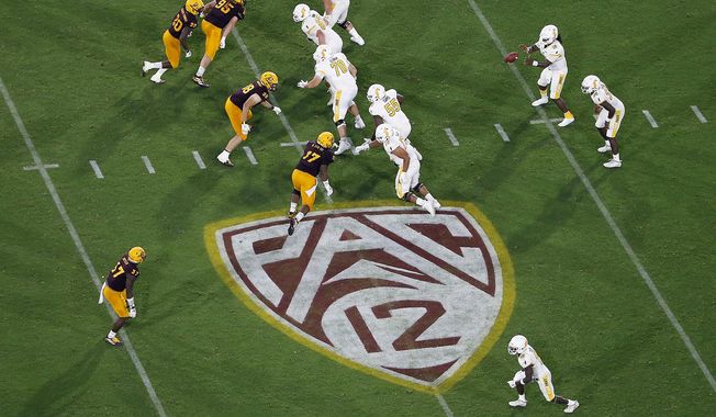 The Pac-12 logo is shown during the second half of an NCAA college football game between Arizona State and Kent State, in Tempe, Ariz. on Aug. 29, 2019. The Pac-12 will provide more access to players and coaches during broadcasts of football games next season, including in-game coaches interviews and halftime camera access. The changes will be implemented throughout football broadcasts on ESPN, Fox Sports and the Pac-12 Networks. (AP Photo/Ralph Freso, File)
