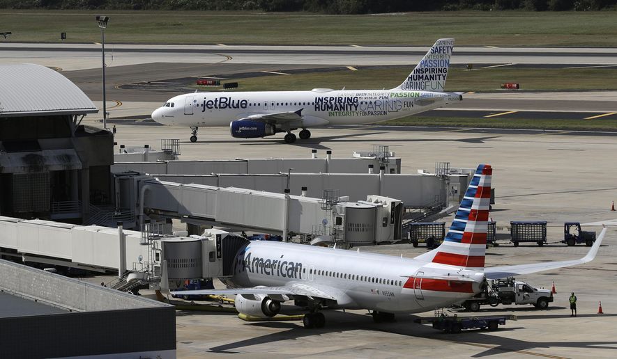 A JetBlue Airbus A320 taxis to a gate on Oct. 26, 2016, after landing, as an American Airlines jet is seen parked at its gate at Tampa International Airport in Tampa, Fla. The two airlines must abandon their partnership in the northeast United States, a federal judge in Boston ruled Friday, May 19, 2023, saying that the government proved that the deal reduces competition in the airline industry. (AP Photo/Chris O&#x27;Meara, File)