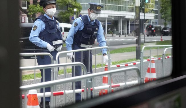 Police officers preparing fence for the road block on the street are seen though a commuter bus during the Group of Seven (G-7) nations&#x27; meetings Saturday, May 20, 2023, in Hiroshima, western Japan. (AP Photo/Eugene Hoshiko)