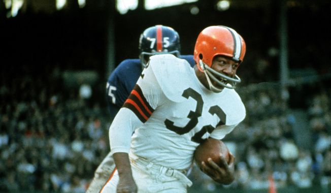 Jimmy Brown (32), running back for the Cleveland Browns, is shown in action against the New York Giants in Cleveland, Ohio, on Nov. 14, 1965. NFL legend, actor and social activist Jim Brown passed away peacefully in his Los Angeles home on Thursday night, May 18, 2023, with his wife, Monique, by his side, according to a spokeswoman for Brown&#x27;s family. He was 87. (AP Photo/File)