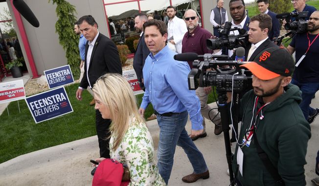 FILE - Florida Gov. Ron DeSantis, center, leaves a fundraising picnic for Rep. Randy Feenstra, R-Iowa, May 13, 2023, in Sioux Center, Iowa. The super PAC promoting Ron DeSantis plans to shoulder the load of organizing support for the Republican presidential prospect ahead of Iowa’s leadoff caucuses. (AP Photo/Charlie Neibergall, File)