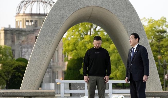 Ukrainian President Volodymyr Zelenskyy, left, and Japanese Prime Minister Fumio Kishida have a talk after laying flowers in front of the Cenotaph for the Victims of the Atomic Bomb at the Hiroshima Peace Memorial Park after he was invited to the Group of Seven (G7) nations&#x27; summit in Hiroshima, western Japan Sunday, May 21, 2023. The Atomic Bomb Dome is seen in the background. (AP Photo/Eugene Hoshiko, Pool)