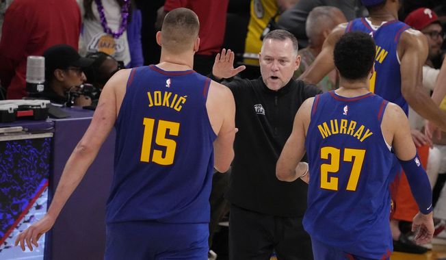 Denver Nuggets head coach Michael Malone, center, shakes hands with Denver Nuggets center Nikola Jokic (15) and guard Jamal Murray (27) in the second half of Game 3 of the NBA basketball Western Conference Final series against the Los Angeles Lakers Saturday, May 20, 2023, in Los Angeles. (AP Photo/Mark J. Terrill) **FILE**