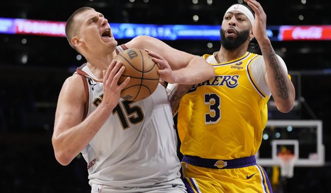 Denver Nuggets center Nikola Jokic (15) is defended by Los Angeles Lakers forward Anthony Davis (3) in the second half of Game 4 of the NBA basketball Western Conference Final series Monday, May 22, 2023, in Los Angeles. (AP Photo/Ashley Landis)