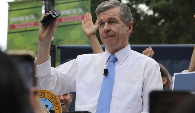 North Carolina Democratic Gov. Roy Cooper affixes his veto stamp to a bill banning nearly all abortions after 12 weeks of pregnancy at a public rally Saturday, May 13, 2023, in Raleigh, N.C. The veto launches a major test for leaders of the GOP-controlled General Assembly to attempt to override Cooper’s veto after they recently gained veto-proof majorities in both chambers. (AP Photo/Hannah Schoenbaum)