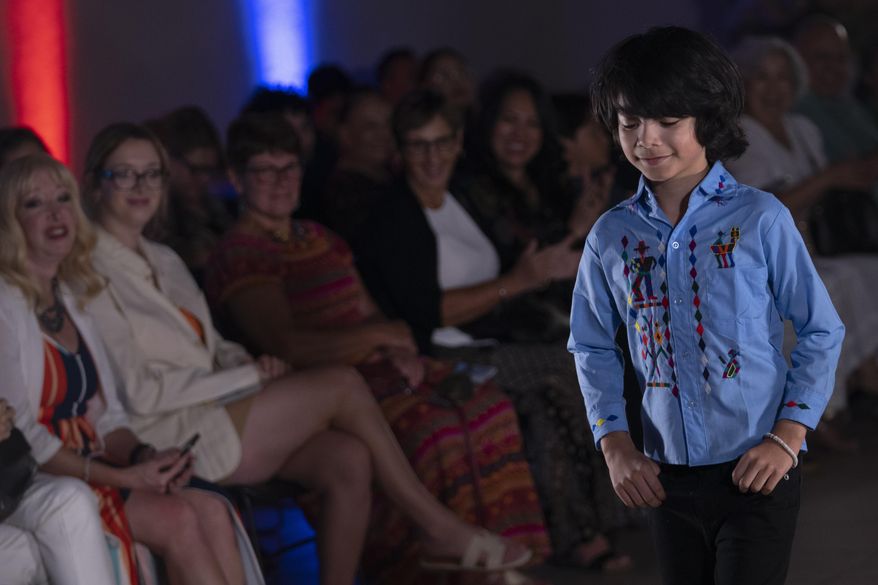 A model struts a garment during a fashion show featuring Guatemalan textiles, Friday, May 12, 2023, in Brownsville, Texas. A Guatemala-born designer combined indigenous weaving technique, modern clothing design and colorful history from her native country came together on a recent weekend on on a runway showcase. The fashion show offered a taste of not only Elena De León's artistic vision, but of the work by mothers living in the U.S. or back in their country to support their families. (AP Photo/Julio Cortez)
