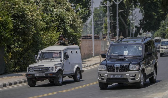 An Indian policeman is seen on top of a police vehicle leading a cavalcade of delegates from the Group of 20 nations as they arrive to participate in a tourism meeting in Srinagar, Indian controlled Kashmir, Monday, May 22, 2023. The meeting scheduled for later Monday is the first significant international event in Kashmir since New Delhi stripped the Muslim-majority region of semi-autonomy in 2019. (AP Photo/Mukhtar Khan)
