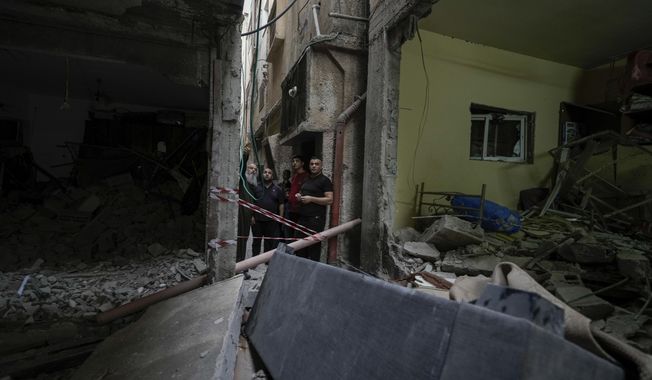 Palestinians inspect a damaged building following an Israeli army raid in the Balata refugee camp near the West Bank town of Nablus Monday, May 22, 2023. Palestinian health officials say Israeli fire has killed at least three people in a West Bank refugee camp. (AP Photo/Majdi Mohammed)