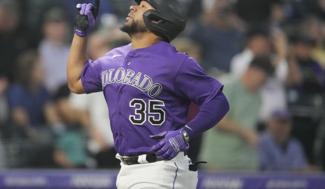 Colorado Rockies&#x27; Elias Diaz gestures as he crosses home plate after hitting a solo home run off Miami Marlins starting pitcher Edward Cabrera in the sixth inning of a baseball game Monday, May 22, 2023, in Denver. (AP Photo/David Zalubowski)