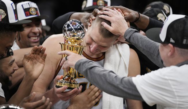 Denver Nuggets center Nikola Jokic is mobbed by teammates after accepting the series MVP trophy in after Game 4 of the NBA basketball Western Conference Final series Monday, May 22, 2023, in Los Angeles. (AP Photo/Ashley Landis)