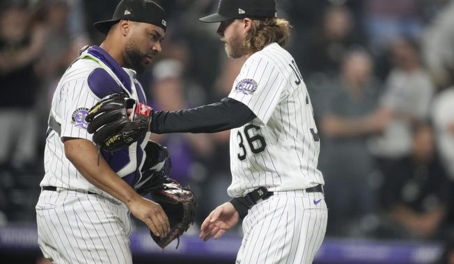 Colorado Rockies catcher Elias Diaz, left, congratulates relief pitcher Pierce Johnson after the team&#x27;s win over the Miami Marlins in a baseball game Tuesday, May 23, 2023, in Denver. (AP Photo/David Zalubowski)